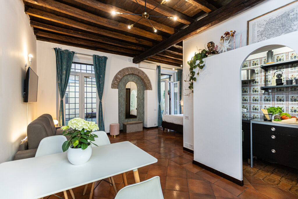 Living and dining room with timber beams and an arched doorway