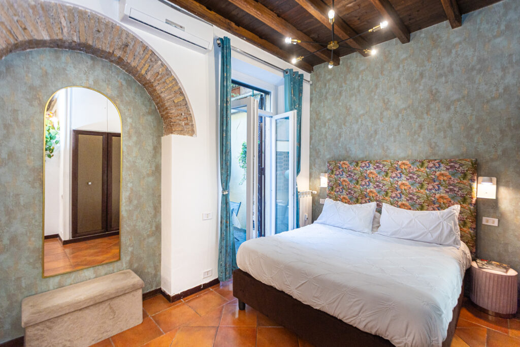 Bedroom with a floral headboard beside a brick arch
