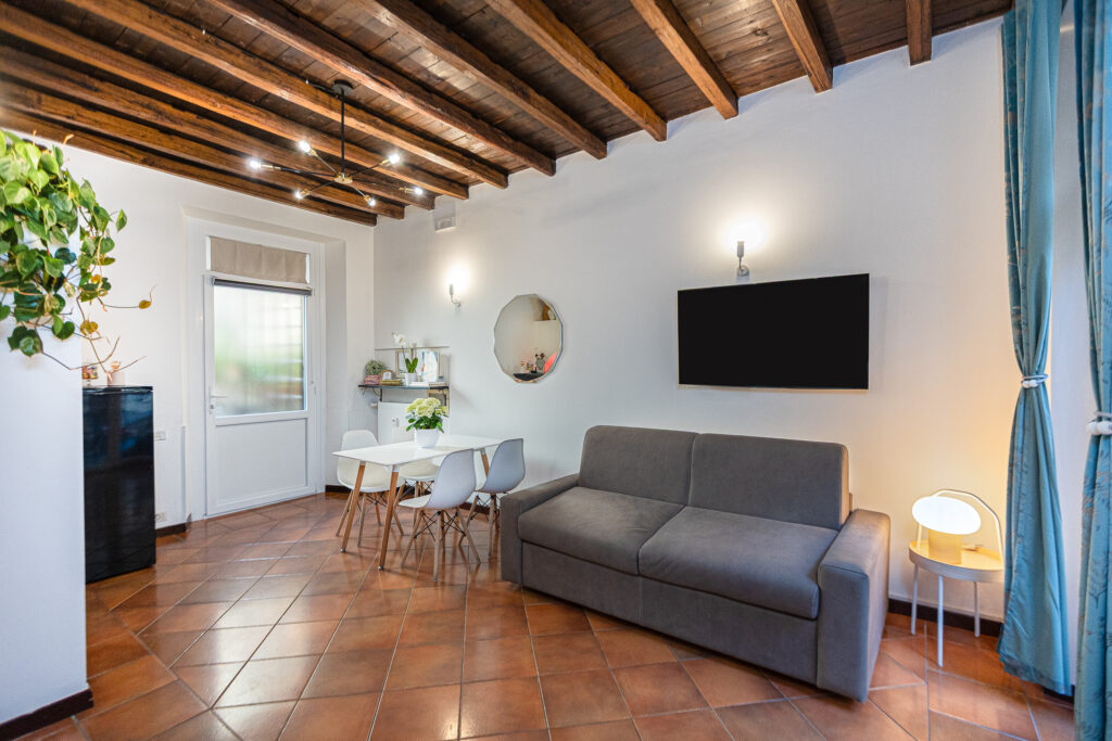 Living room with sofa, wall-mounted television and dining table