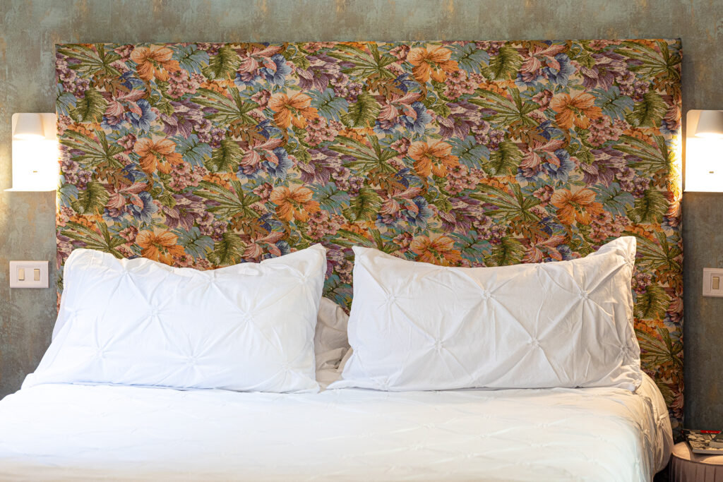 Floral headboard, white pillows and bedside reading lights