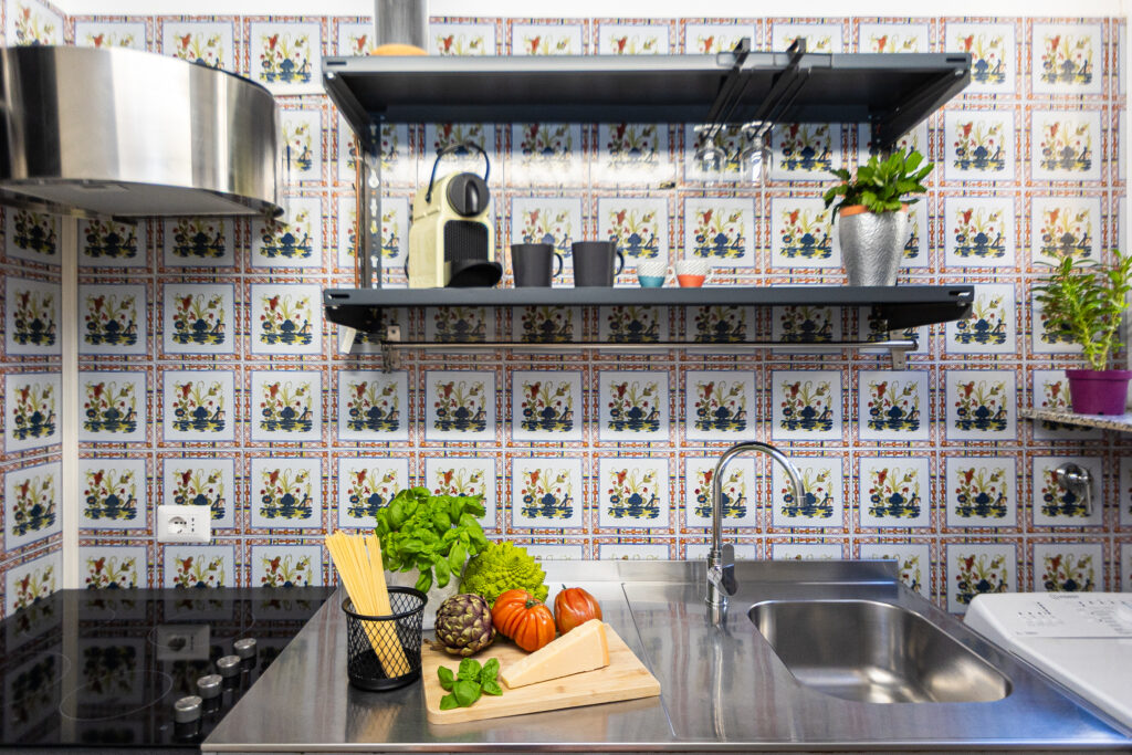 Kitchen with patterned tiles, stainless steel sink and cooking area