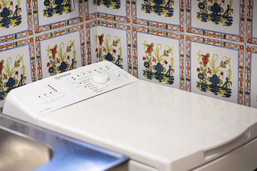 Washing machine beneath decorative kitchen tiles