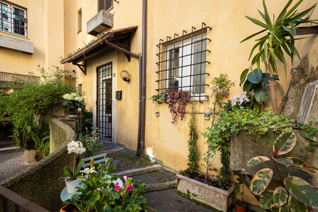 Apartment entrance with plants beside the courtyard